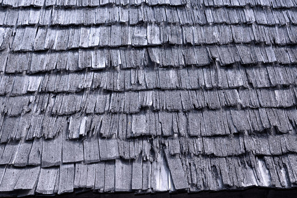 古い壊れた木製のシングルテクスチャ。修復が必要な損傷した伝統的な屋根 - 写真・画像