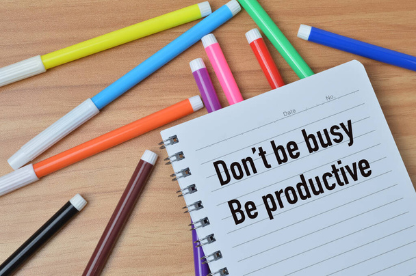Top view of notebook written with DON'T BE BUSY BE PRODUCTIVE - Foto, Bild