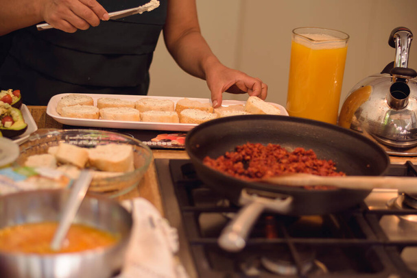 Вид на кухню, где готовят тарелку с жареным мясом и роллы с десертами и авокадо - Фото, изображение