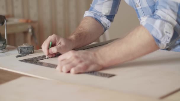 Ξυλουργός κάνει σημάδια μολύβι στο κενό με τη βοήθεια ενός χάρακα - Πλάνα, βίντεο