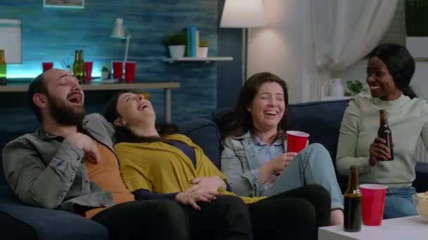 Amigos multiétnicos que tienen una reacción divertida mientras ven la película de comedia - Metraje, vídeo