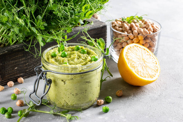 健康的なアボカドのフムスとオリーブオイルと緑のエンドウ豆.ベジタリアンのコンセプト、選択的フォーカス. - 写真・画像