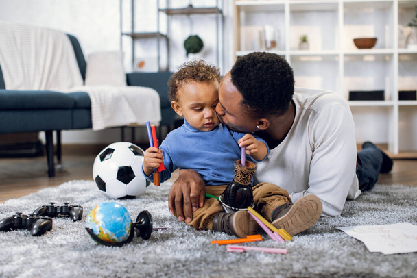 Young father and son playing with toys on carpet - Photo, image