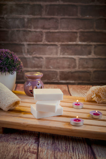 Gyönyörű spa kompozíció természetes szappanok illatos gyertyák és fürdőszoba tartozékok egy romantikus környezetben a tisztító koncepció. Van sekély mélysége mező és hely a szövegnek. - Fotó, kép