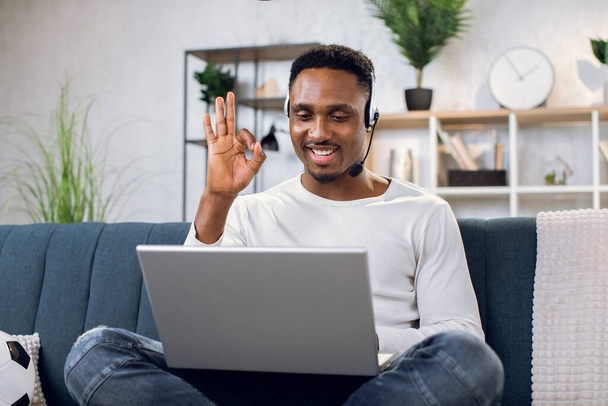 Afro american man using laptop for video conference at home - 写真・画像