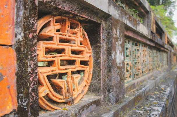 Κοντινές λεπτομέρειες ενός μοτίβου του κινεζικού συμβόλου για μακροβιότητα κατά μήκος ενός αρχαίου πέτρινου τείχους στην ιστορική ακρόπολη της πόλης Hue, Βιετνάμ - Φωτογραφία, εικόνα