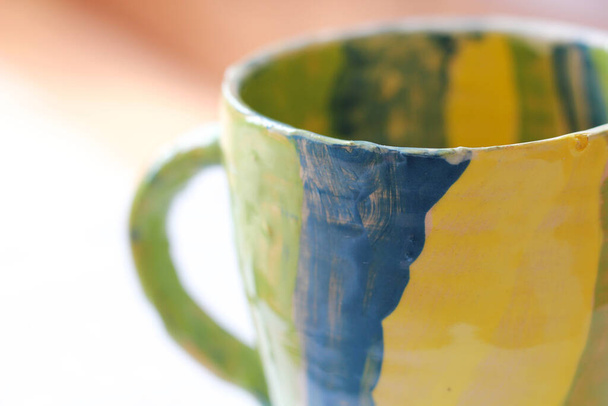 Taza de cerámica hecha a mano en color amarillo verde y azul - Foto, Imagen