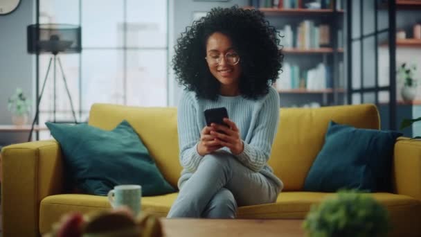 Latin Female Using Smartphone in Living Room - Video, Çekim
