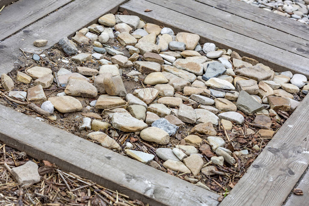 Ακατέργαστη ακατέργαστη φυσική πέτρα στο καθημερινό περιβάλλον, κηπουρική και διαμόρφωση κήπων - Φωτογραφία, εικόνα
