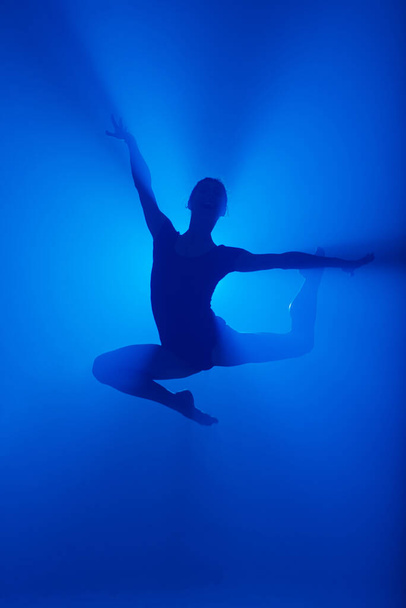 Profi balerina táncos balett a füstben. Nő fekete test ruha reflektorfényben háttér. - Fotó, kép