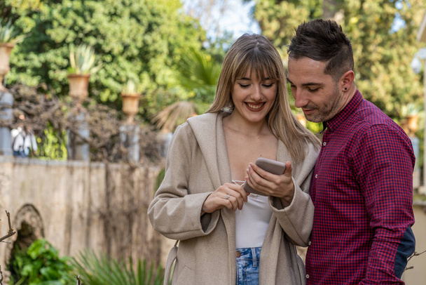 Young Caucasian couple looking at a photo on the smartphone - Foto, Imagem
