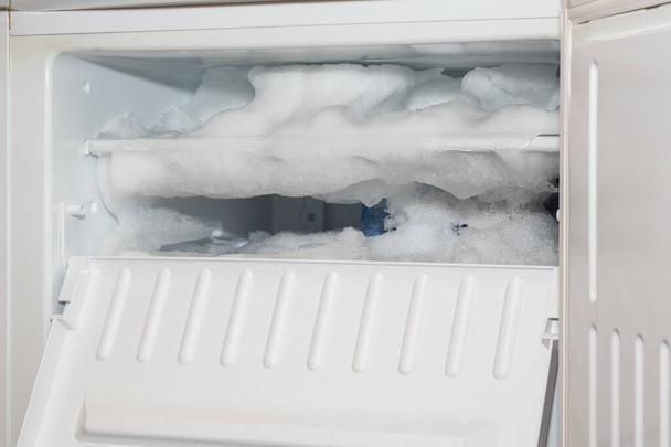 Buzdolabı kalın bir buz ve kar tabakasıyla kaplı. - Fotoğraf, Görsel