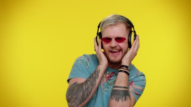Χαρούμενος ελκυστικός άνθρωπος ακούγοντας μουσική μέσω ακουστικών και χορεύοντας ντίσκο χαζολογώντας διασκεδάζοντας - Πλάνα, βίντεο