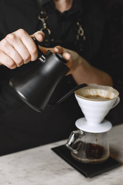 Ground black coffee is brewed in a kemex - 写真・画像