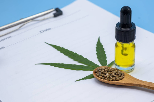 Konopný olej, semena v dřevěné lžíci a konopný list umístěný na lékařský předpis Koncepty alternativní medicíny, bylinné prostředky Lékařský výzkum marihuany - Fotografie, Obrázek