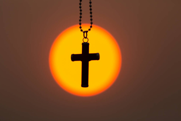 Le crucifix au milieu du lever ou du coucher du soleil. Le concept de christianisme, une bénédiction de la prière à Jésus. Croyez en Dieu, priez pour la lutte et la victoire de Dieu. - Photo, image