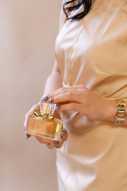 elegante sensual mujer joven con perfume, tonos dorados - Foto, imagen