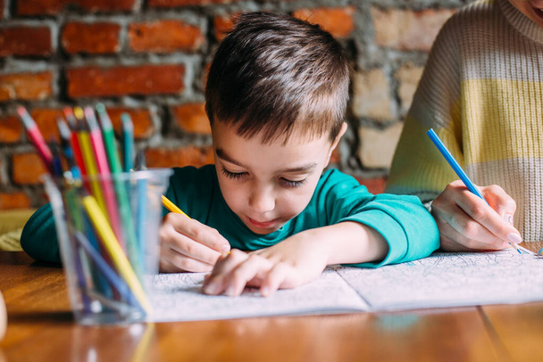 Evde ya da kafede mutlu bir anaokulu çocuğunun portresi çiziliyor.. - Fotoğraf, Görsel