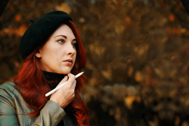 Brooding red-haired woman in the park. - Foto, Imagen