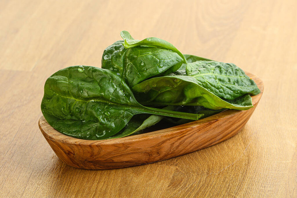 Fresh green spinach leaves in the bowl over wooden background - Photo, Image
