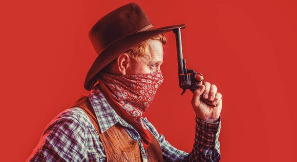 Портрет ковбоя. Запад, оружие. Портрет ковбоя. Американский бандит в маске, западный человек в шляпе. Портрет ковбоя в шляпе - Фото, изображение