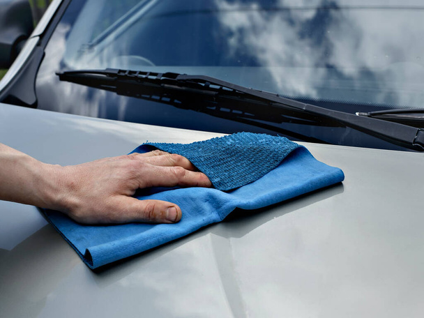 Autó részletezése és tisztítása kézzel és mikroszálas törölköző. Polírozás az autó külseje autós fényezés termékek vagy viasz eredményeként a fényes felület. - Fotó, kép