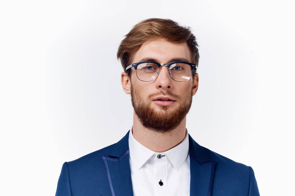 portrét pohledného muže v brýlích a v klasickém obleku na světlém pozadí - Fotografie, Obrázek