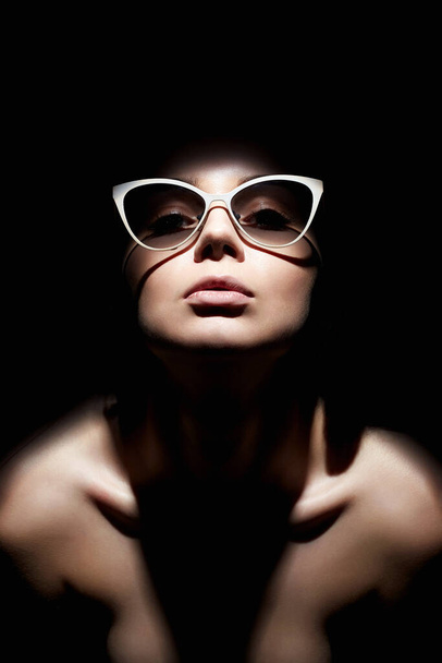 Gözlüklü güzel bir kadının portresi. Karanlıktan bakan Bayan Kız - Fotoğraf, Görsel