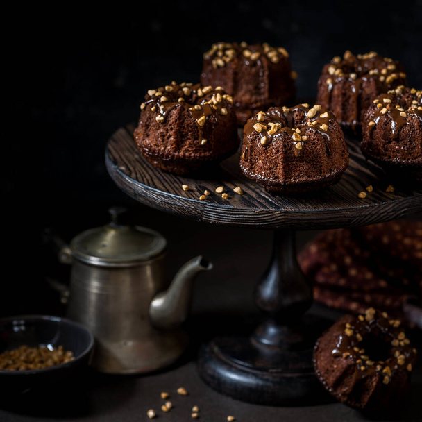 Mini Chocolate Bundt Cakes Topped with Cocoa Icing and Chopped Nuts, square - Foto, imagen