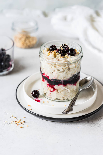 Layered Creamy Oat Porridge in a Jar with Blackcurrants and Chopped Almonds, copy space for your text - Fotografie, Obrázek