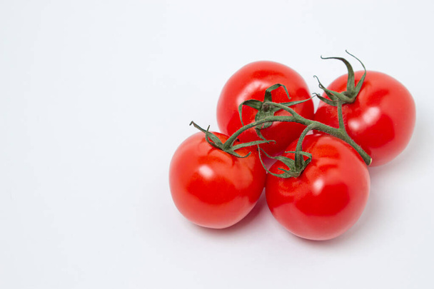 Tomatoes on a vine on a white background. Fresh and healthy vegetable. Ripe and juicy tomato - Photo, Image