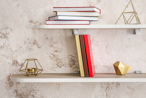 Shelf with books and decor on light background - Photo, Image