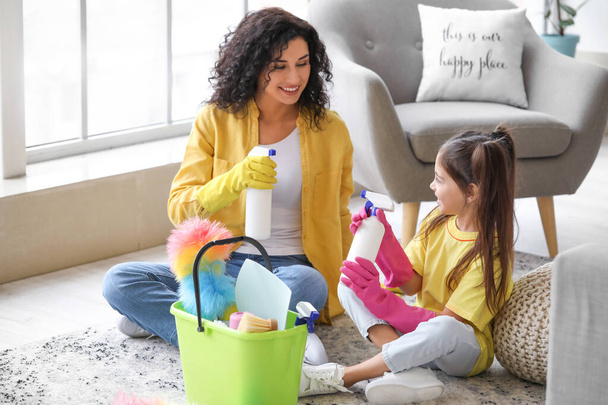 Mother and daughter having fun while cleaning their flat - 写真・画像