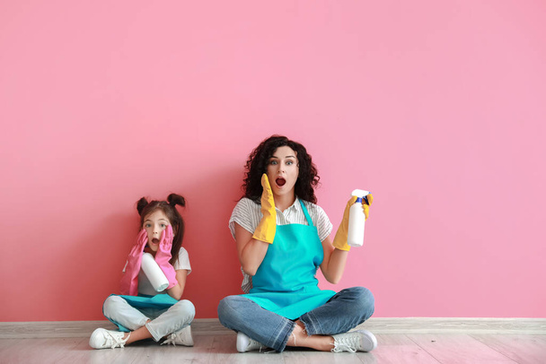Мать и дочь с чистящими средствами на цветном фоне - Фото, изображение