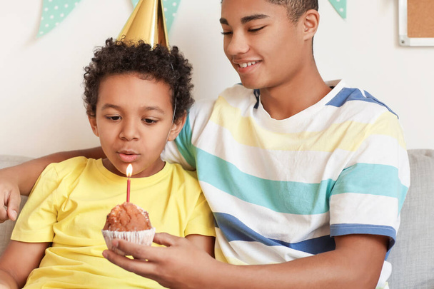 Petit garçon soufflant bougie sur gâteau d'anniversaire à la maison - Photo, image