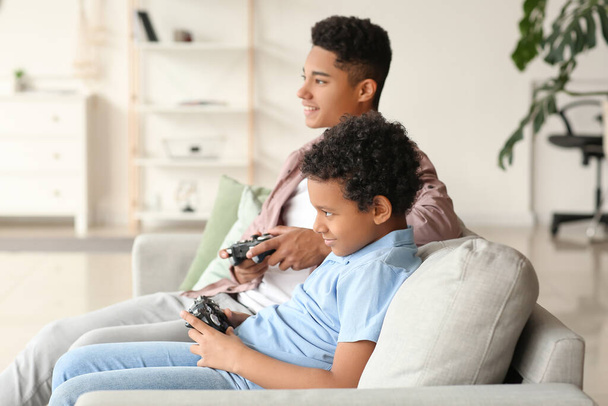 アフリカ系アメリカ人の男の子が自宅でビデオゲームをプレイ - 写真・画像