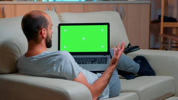 Konzentrierte Mann suchen Laptop-Computer mit bei Attrappe grünen Bildschirm Chroma-Tastatur-Display - Foto, Bild