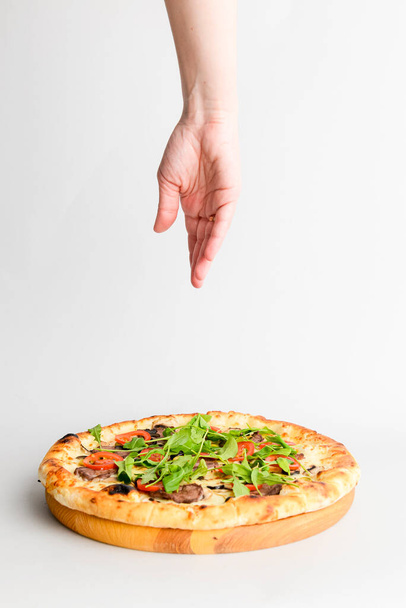 Tasty pizza with meat, mushrooms, tomatoes and basil isolated on white. Hands reaching for pizza. Copy space banner, vertical banner, Italian cuisine concept. Traditional pizza recipe. - Foto, imagen