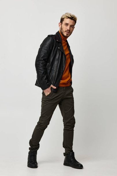 chaqueta de cuero hombre brutal suéter naranja pantalones modelo - Foto, imagen