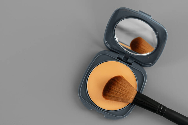 Open box with make up face powder on gray background - Φωτογραφία, εικόνα