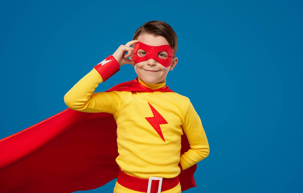 Smiling boy in superhero costume and mask - 写真・画像