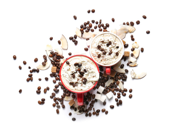 Tassen mit leckerem Kaffee und Kokosraspeln auf weißem Hintergrund - Foto, Bild
