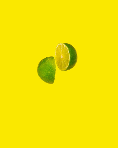 abstract minimal idea.green lime on yellow background.floating fruit - Фото, зображення