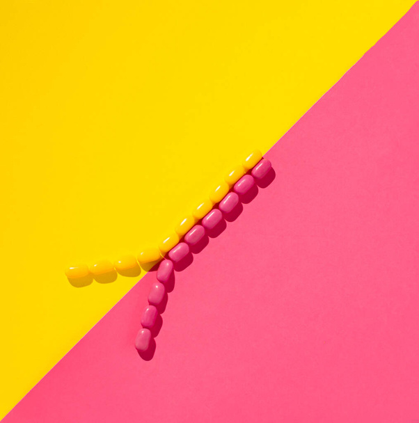 candys arrangment.minimal flat lay creative concept.pink and yellow background and top view - Photo, Image