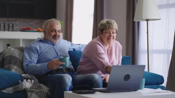 starší manželé komunikují prostřednictvím online video chatu s přáteli nebo dětmi, důchodci sedí spolu doma - Záběry, video