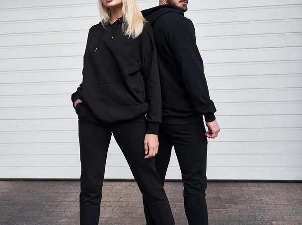 Mulher e homem usam capuz preto sem um logotipo. Sem logotipo sportswear básico. Moletom de camisola de manga longa - Foto, Imagem