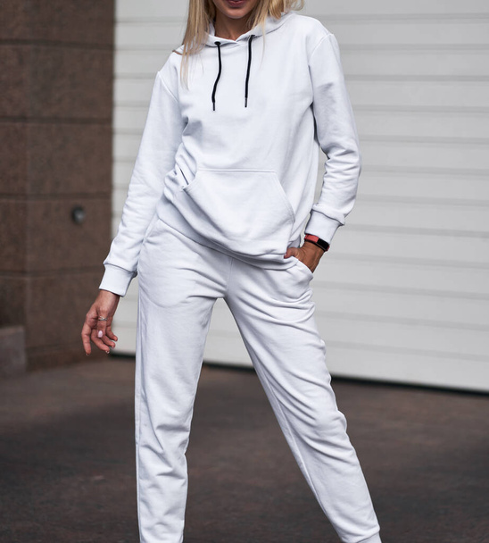 for Girl wears white hoodie and pants. Blonde woman in loose tracksuit with no logo - Photo, Image