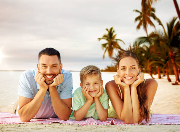 happy family lying over tropical beach background - 写真・画像