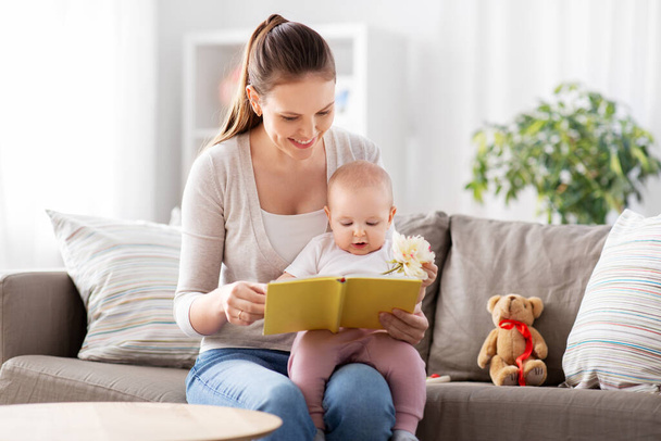 happy mother reading book to little baby at home - 写真・画像