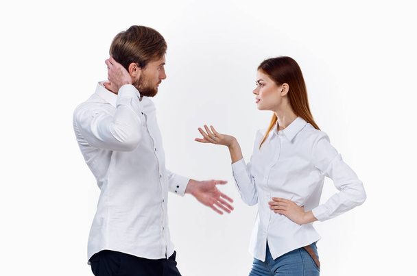 una mujer en una camisa gestos con las manos y mira a un joven empleado socios - Foto, imagen